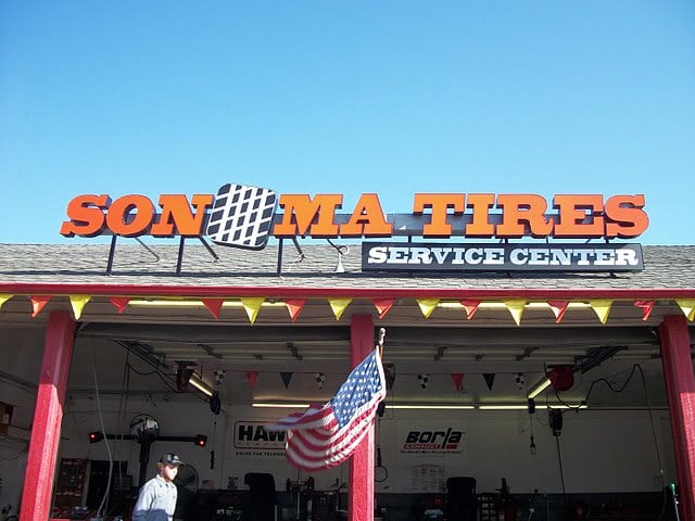 commercial exterior tire service center u.s. flag person walking